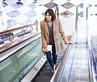 Woman riding up an escalator